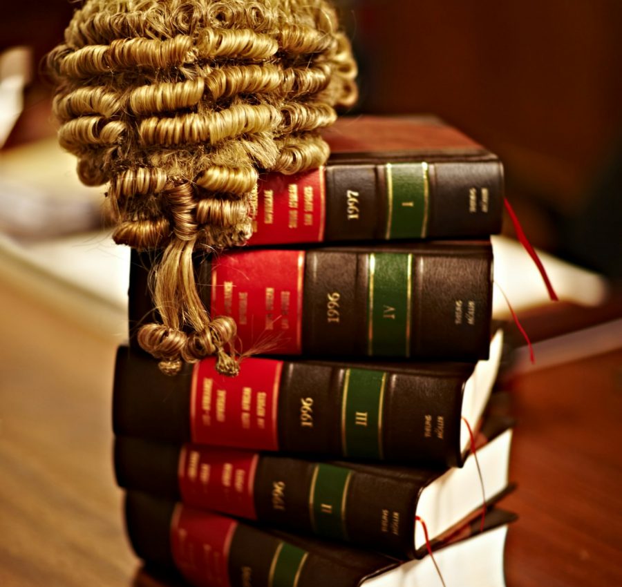 Knowledge of the law is crucial for a fair trial. Shot of legal books and a wig on top of a table.